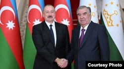 Azerbaijani President Ilham Aliyev (left) and Tajik President Emomali Rahmon shake hands in Dushanbe on September 14.