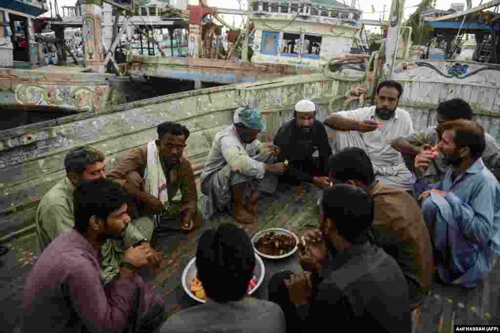 Fishermen break their iftar fast on a boat during the holy month of Ramadan at a dockyard in the port city of Karachi, Pakistan.