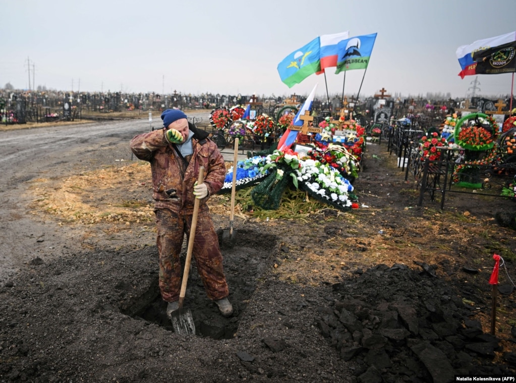 Një varrmihës pushon gjatë punës së tij pranë varreve të ushtarëve rusë në Yefremov, në rajonin Tula në Rusi, në mars 2023. &nbsp;