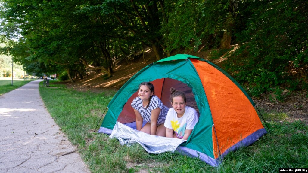 Dy vajza shihen në një tendë nën hije në Parkun e Gërmisë. 18 korrik 2023.