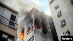 Zgrada gori nakon raketnih napada iz pojasa Gaze, u Tel Avivu, Izrael, 7. oktobra 2023.