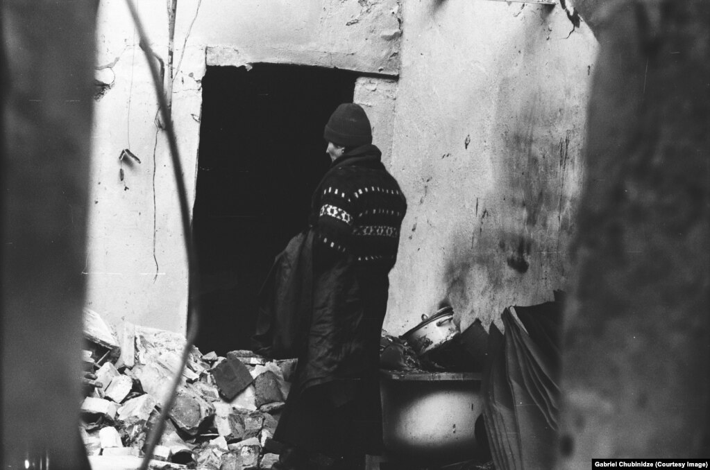 Una donna guarda attraverso un appartamento distrutto nel centro di Tbilisi.