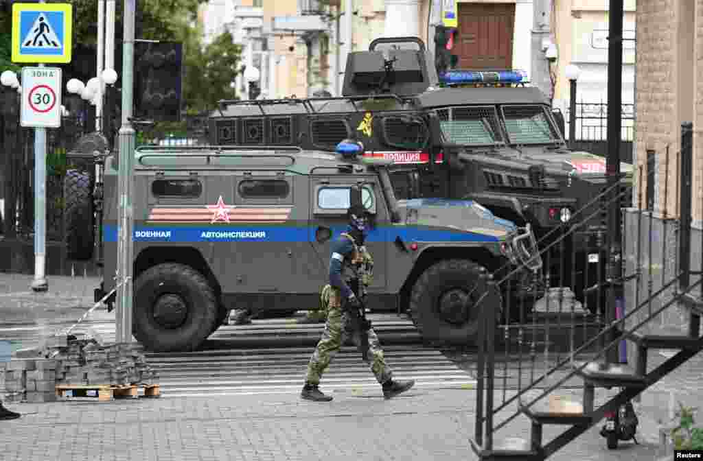 A Wagner fighter seen in front of armored vehicles reportedly belonging to the Russian military in Rostov-on-Don.&nbsp;