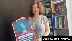 Novinarka Nino Zuriašvili sa plakatom na kojoj je njena fotografija i natpis "U Gruziji nema mjesta za agente"