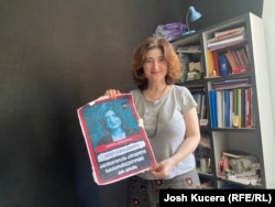 Novinarka Nino Zuriašvili sa plakatom na kojoj je njena fotografija i natpis "U Gruziji nema mjesta za agente".