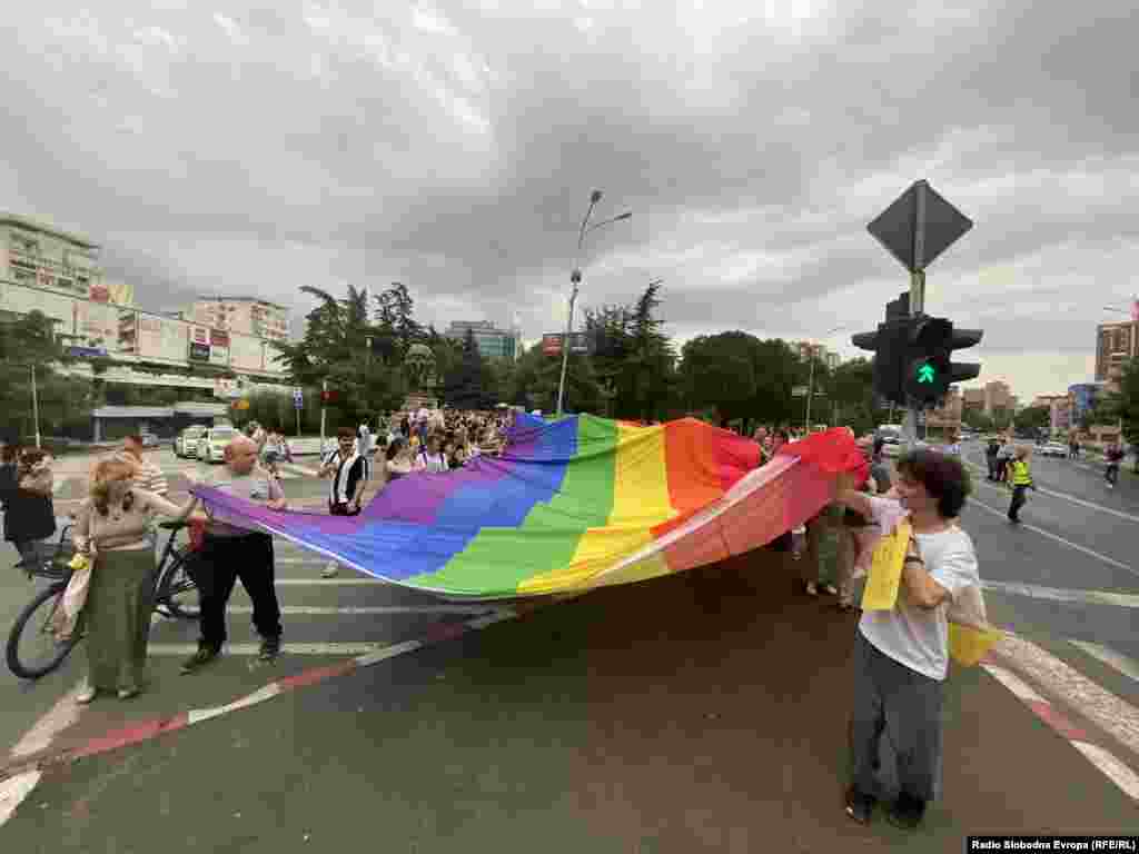 Protestna šetnja ulicama Skoplja pod zastavom u duginim bojama.