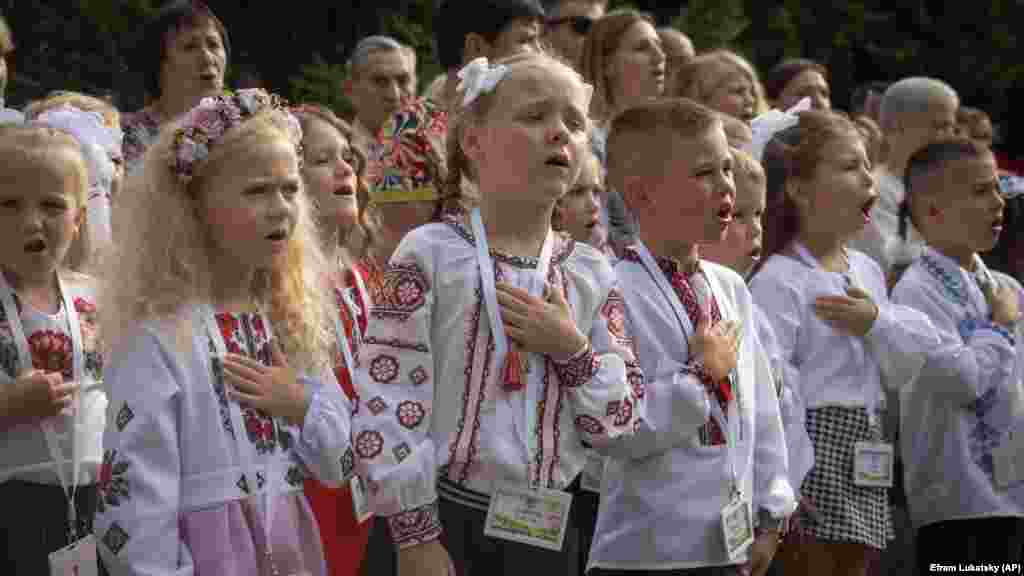 Iskolások éneklik Ukrajna nemzeti himnuszát az első tanítási napon tartott ünnepségen a Kijev melletti Bucsában &nbsp;