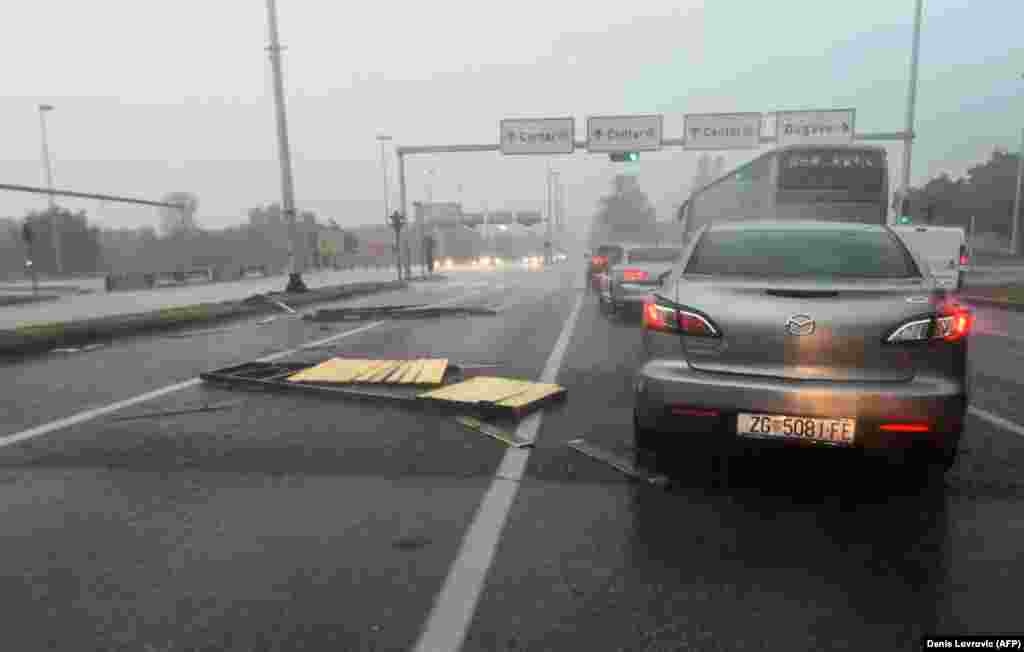 Një veturë duke kaluar pranë shenjave të rrënuara të trafikut, pas stuhisë së papritur në Zagreb, Kroacia. 19 korrik 2023.