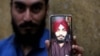 Harmindar Sikh shows the photo of his brother Manmohan Singh, reportedly killed by IS-K militants in Peshawar on June 25.