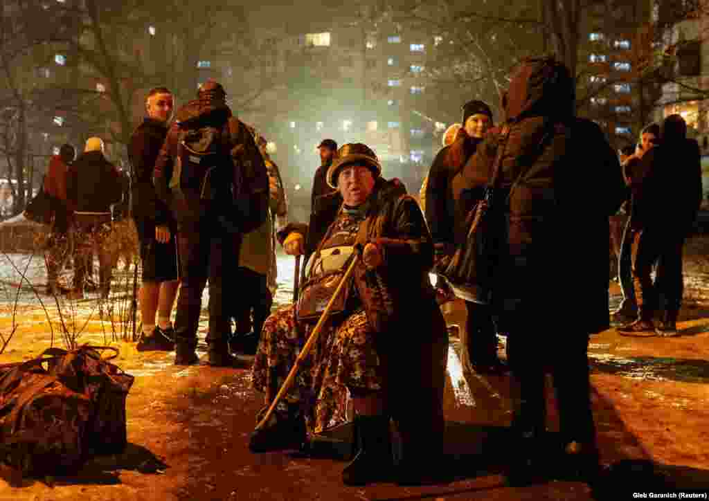 Residents gather outside their apartment building damaged in an early morning Russian ballistic missile attack in Kyiv on December 13. Ukraine claimed on Telegram to have downed 10 ballistic missiles that targeted the capital.