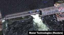 Повреждения дороги над плотиной Каховской ГЭС на спутниковом снимке Maxar Technologies, сделанном 28 мая 2023 года