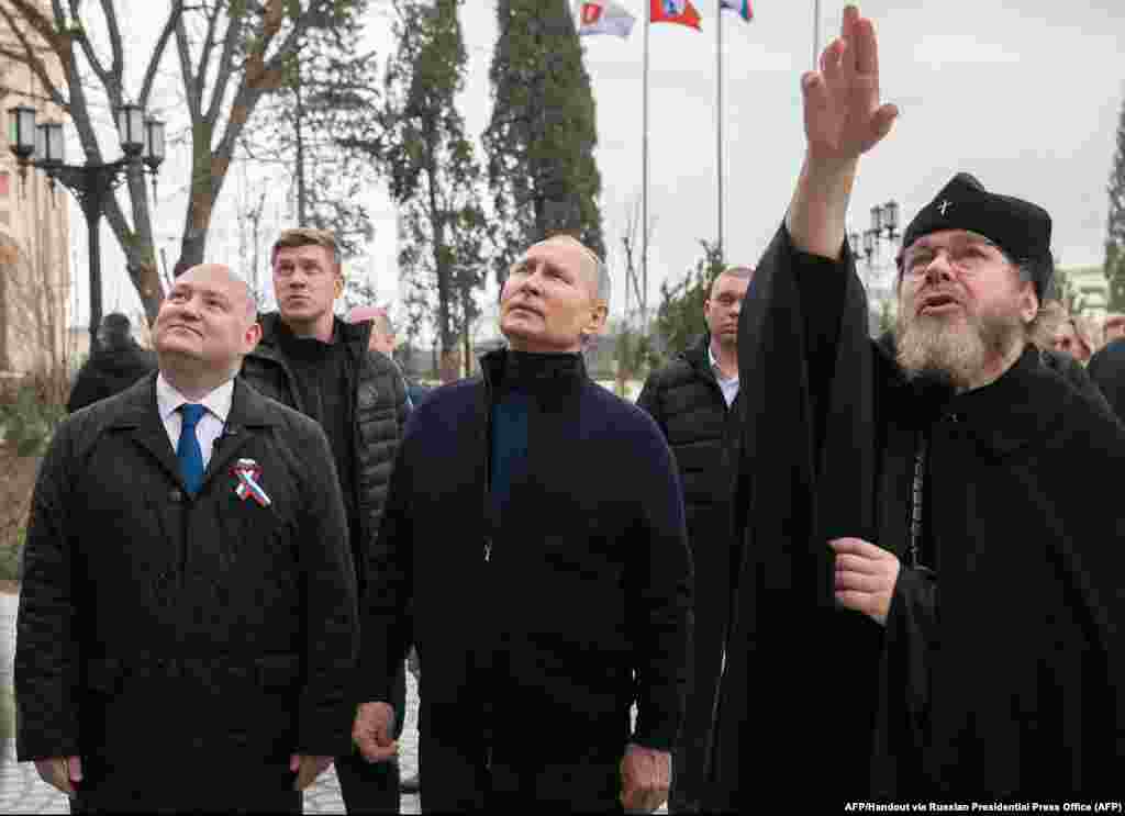 Vlagyimir Putyin&nbsp;orosz elnök Tihon Sevkunovval, a Kultúra Pátriárkai Tanácsának elnökével (jobbra) és Mikhail Razvozhajev (balra) szevasztopoli kormányzóval.&nbsp;Március 18-án, szombaton látogatott el Putyin a Krímbe, a félsziget annektálásának kilencedik évfordulójának alkalmából. A&nbsp;háború kezdete óta ez volt az orosz elnök első útja Ukrajna orosz megszállás alatt álló területeire