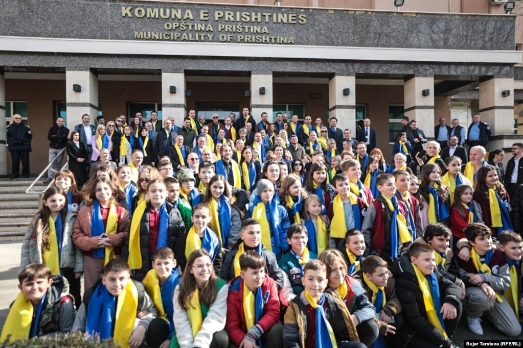 Një grup fëmijësh në Prishtinë me shalle me ngjyrat e flamurit të Ukrainës, më 24 shkurt.