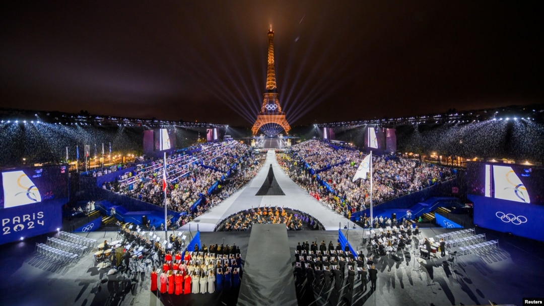 O fotografie realizată din elicopter pe 26 iulie 2024 arată o vedere aeriană a Turnului Eiffel și a Inelelor Olimpice iluminate în timpul ceremoniei de deschidere a Jocurilor Olimpice Paris 2024 din Paris.