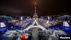 O fotografie realizată din elicopter pe 26 iulie 2024 arată o vedere aeriană a Turnului Eiffel și a Inelelor Olimpice iluminate în timpul ceremoniei de deschidere a Jocurilor Olimpice Paris 2024 din Paris.