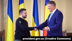President Ukrainian Volodymyr Zelenskiy and his Romanian counterpart, Klaus Iohannis, shake hands in Bucharest on October 10. 