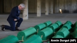 Ambasador SAD Michael Murphy kleči ispred tabuta trideset žrtava genocida u Srebrenici koji će biti ukopani 11. jula u Potočarima, 10. jul 2023. gdine