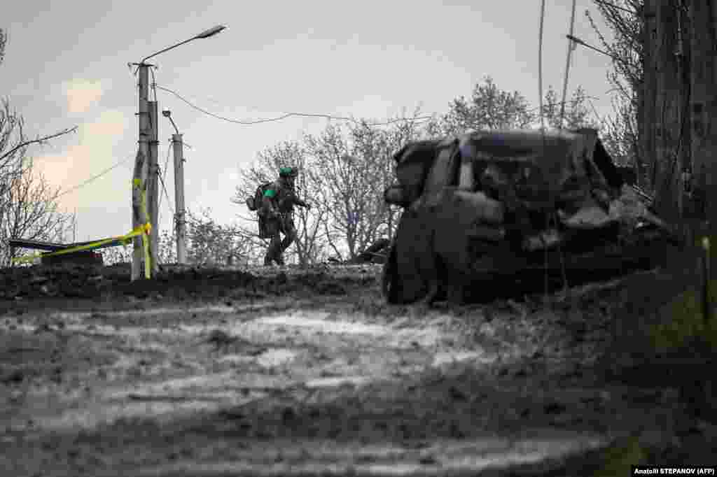 A Ukrainian soldier runs for cover from Russian shelling in Bakhmut. &nbsp;