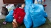 Children huddle up for warmth as they try to sleep on the pavement with their belongings in the Hungarian town of Kocs, about 70 kilometers west of Budapest, on August 22. They were evicted from a privately owned shelter after a Hungarian government directive limited free shelter to refugees from conflict-affected regions of Ukraine.