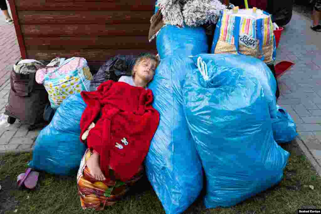  A young refugee girl from Ukraine sleeps on bags of clothing in the northwestern Hungarian village of Kocs. She is part of a group of about 120 refugees from western Ukraine evicted from a privately run shelter after the Hungarian government decided to continue supporting only refugees from areas directly affected by military operations.&nbsp; &nbsp; 