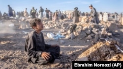 Un băiat afgan plânge lângă mormântul fratelui său mai mic, decedat în cutremurul de sâmbătă, în districtul Zenda Jan din provincia Herat, în vestul Afganistanului, luni, 9 octombrie 2023.