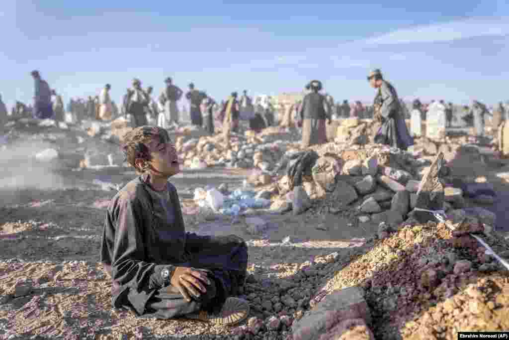 An Afghan boy mourns next to the grave of his little brother on October 9 as rescuers dig underneath the rubble of flattened homes.&nbsp;The child died two days earlier in an earthquake that hit the Zindah Jan district of western Afghanistan&#39;s Herat Province. A 6.3-magnitude earthquake struck the same area on October 11, destroying 700 homes in the village of Chahak, which had been untouched by the tremors of previous days.&nbsp; &nbsp;