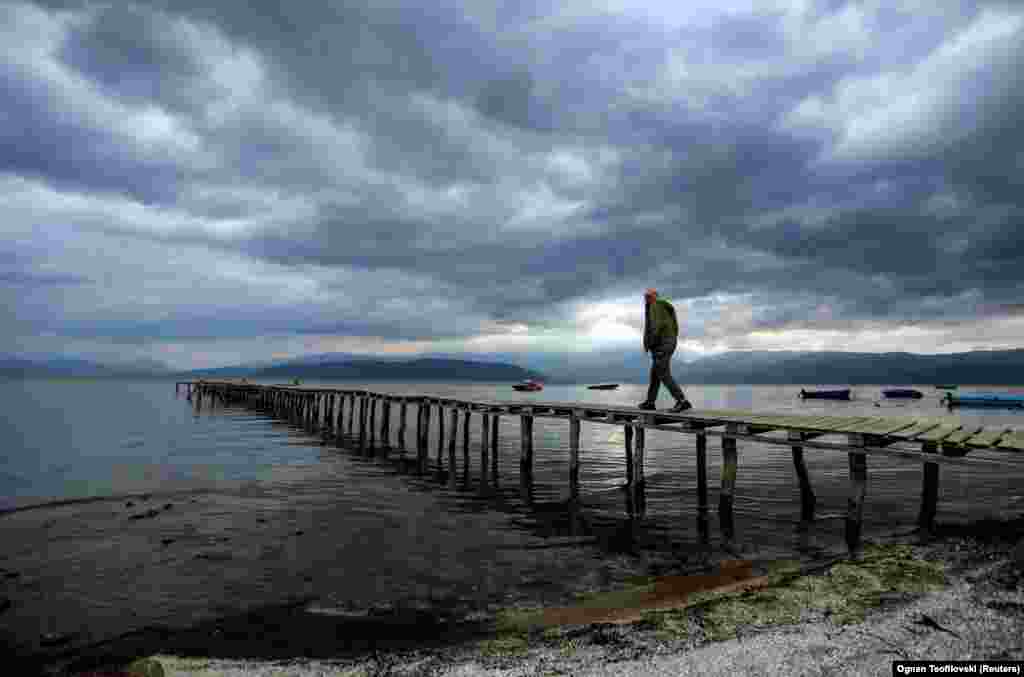 A man walks on a pier in Pretor. In a region where financial troubles, aging infrastructure, and declining fertility rates continue to be the most pressing problems, environmental issues are frequently pushed to the bottom of the list of government priorities.