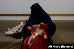 A woman dresses her child at a hospital in Bamiyan.