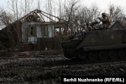 Українські військові їдуть на бронетранспортері М113 селом біля Кремінної, 8 березня 2023 року