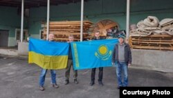 Марат Дарменов (с флагом Украины в руках) с другими волонтёрами, которые помогали людям, пострадавшим от российской оккупации. Фото из архива Марата
