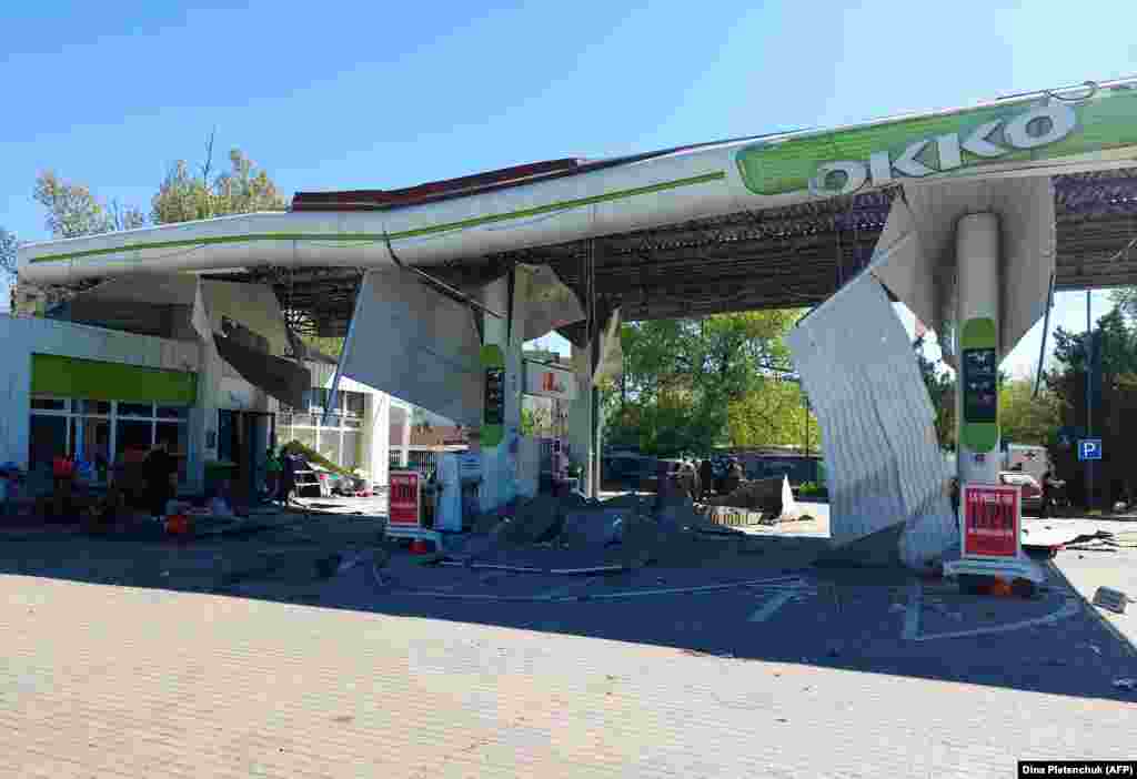На цій фотографії, зробленій 3 травня 2023 року, зображено пошкоджену автозаправну станцію біля будівлі залізничного вокзалу після російського удару по Херсону