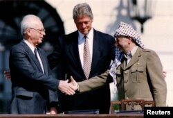 Премьер-министр Израиля Ицхак Рабин, президент США Билл Клинтон и глава Организации освобождения Палестины Ясир Арафат (слева направо) у Белого дома в Вашингтоне после подписания Декларации о принципах, положившей начало созданию Палестинской автономии. 13 сентября 1993 года