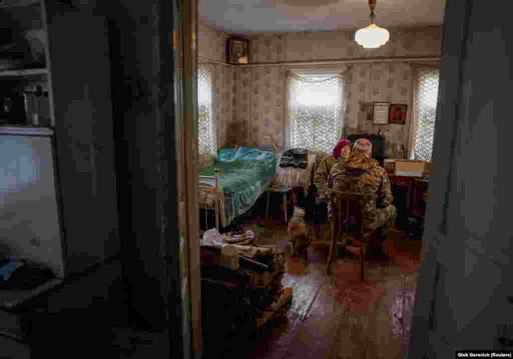 Az idős asszony egy katonával a házában a csernobili atomerőmű-baleset szennyezett zónájában 2023. október 18-án. A zóna területén egy tucat település található