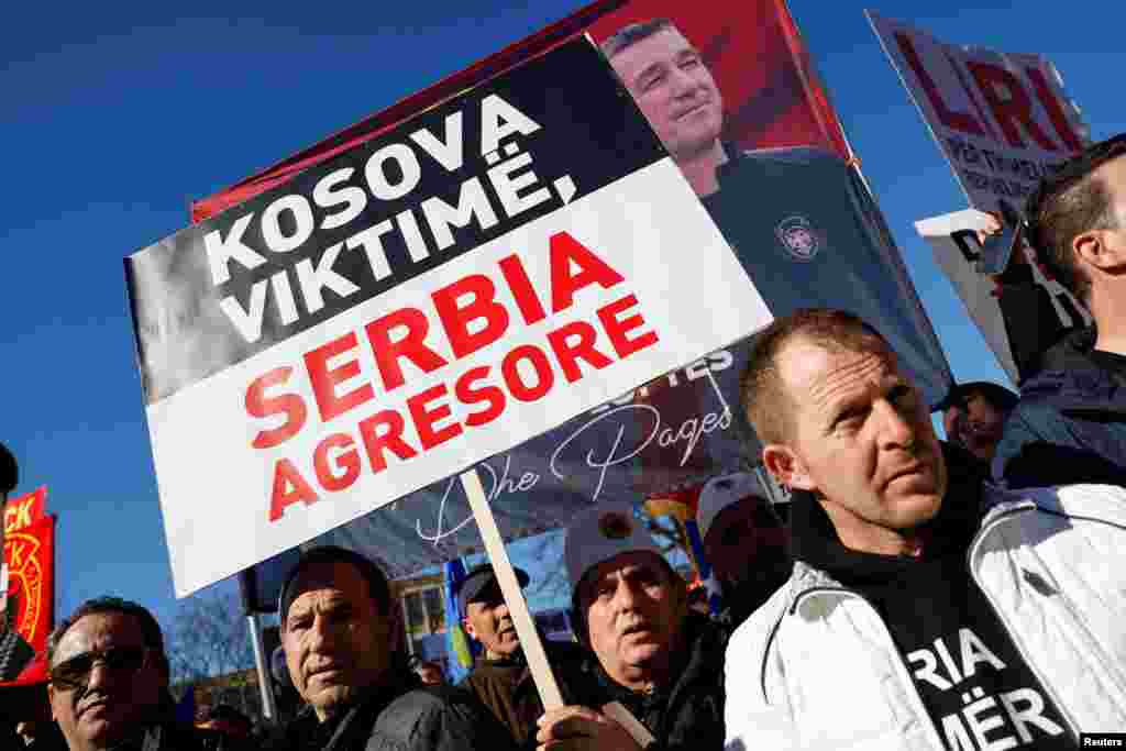 Një burrë mban në duar një pankartë me mbishkrimin "Kosova viktimë, Serbia agresore".