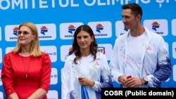 Canotorii Ionela Cozmiu(c) și Marius Cozmiuc (d), purătorii de drapel ai României la ceremonia de deschidere a Jocurilor Olimpice, alături de Elisabeta Lipă (s), președinta Agenției Naționale pentru Sport.