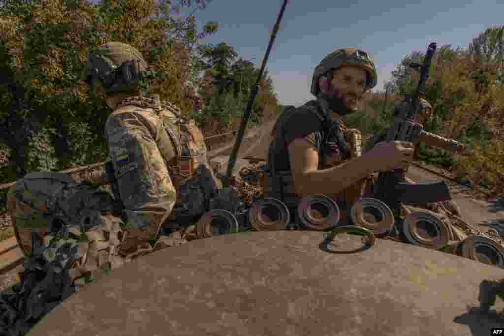 Ukrainian soldiers ride on top of an armored personnel carrier in Kostyantynivka, Donetsk region.