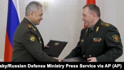 Russian Defense Minister Sergei Shoigu (left) and Belarusian Defense Minister Viktor Khrenin in Minsk on May 25.