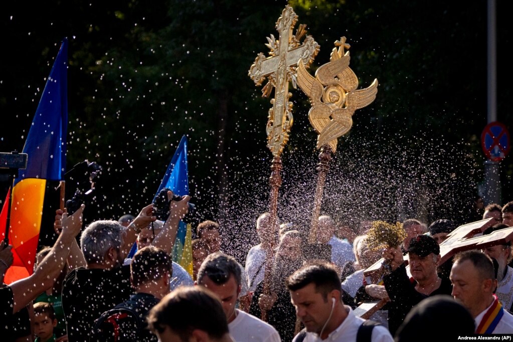 I sacerdoti aspergono l'acqua santa durante una piccola processione religiosa il 30 luglio destinata a compiere un "esorcismo", come dicono i partecipanti, del percorso percorso dal Bucharest Pride Parade, che si è svolto il giorno prima a Bucarest.