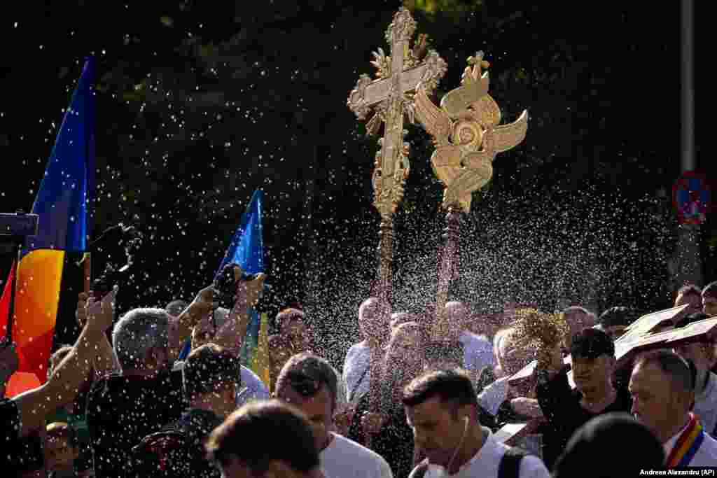 Preoții stropesc cu apă sfințită în cadrul unei mici procesiuni religioase din 30 iulie menită să facă un &bdquo;exorcism&rdquo;, după cum spun participanții, a traseului parcurs de București Pride Parade, care a avut loc cu o zi înainte la București.