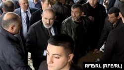 Armenian Prime Minister Nikol Pashinian (center left) is confronted by villagers on the country's border with Azerbaijan on May 25. 