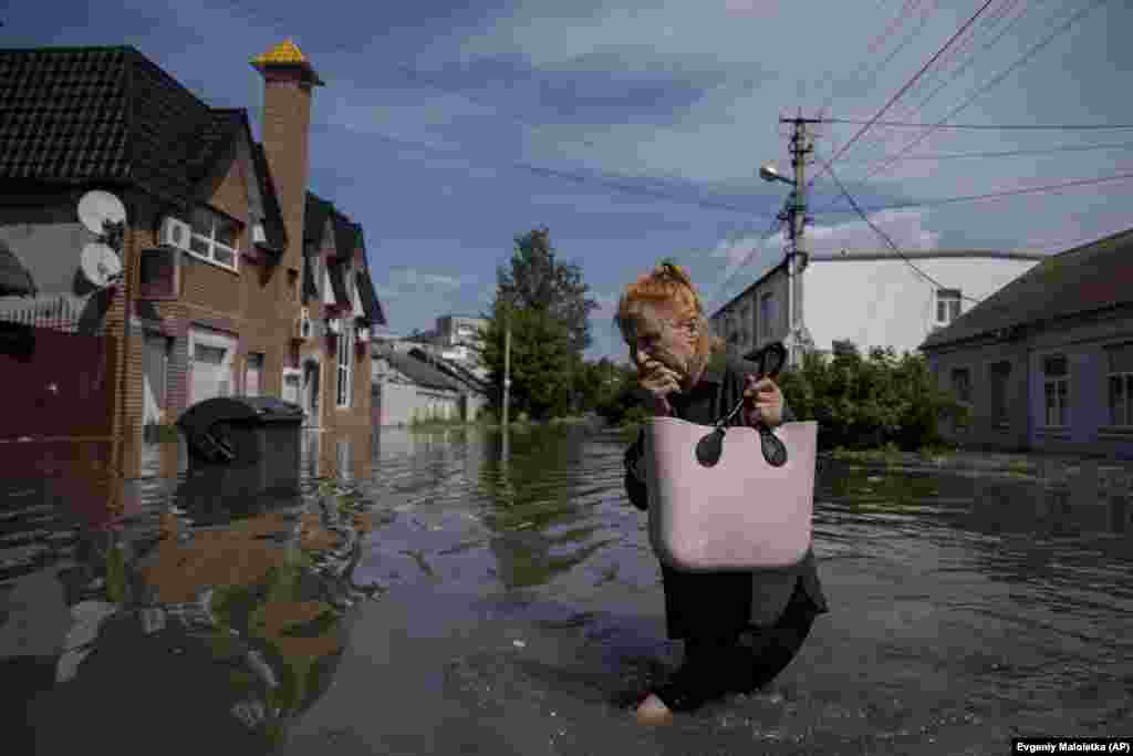 Жена се пробива низ поплавен пат во Херсон. Градот, кој имаше предвоено население од речиси 300.000 луѓе, сега се соочува со нова хуманитарна катастрофа. Голем дел од инфраструктурата на Херсон беше уништена&nbsp;за време на осуммесечната руска окупација.