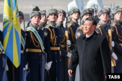 Lideri kinez, Xi Jinping, duke ecur në tepihun e kuq, të shtruar për të para hyrjes në Kremlin.