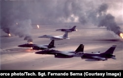 Mlaznjaci F-16 i F-15 (koji se razlikuju po svojim dvostrukim repovima) lete iznad zapaljenih naftnih polja u Iraku 1991. tokom Zalivskog rata.