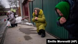 Ožalošćeni kleče dok čekaju da prođe lijes ubijenog civila Oleksandra Maksimenka (38) na njegovom sprovodu u rodnom selu Kniažiči, istočno od Kijeva, Ukrajina, 13. februar 2023.