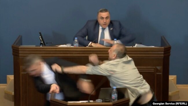 Aleko Elisashvili (bottom right) rushed the podium on the parliamentary floor on April 15 and punched Mamuka Mdinaradze, leader of the parliamentary faction of the ruling Georgian Dream party.
