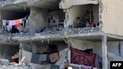 Palestinci sede u uništenoj prostoriji stambene zgrade u južnom pojasu Gaze 22. maja 2024. godine. Ilustrativna fotografija