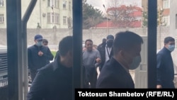 Сотрудники спецслужб ведут Райымбека Матраимова в здание Первомайского райсуда Бишкека.