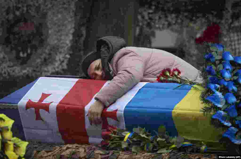 A relative mourns over the coffin of Nodar Nasirov, 28, a volunteer of the Georgian Legion who was killed in a battle against Russian troops, during a funeral in Kyiv.