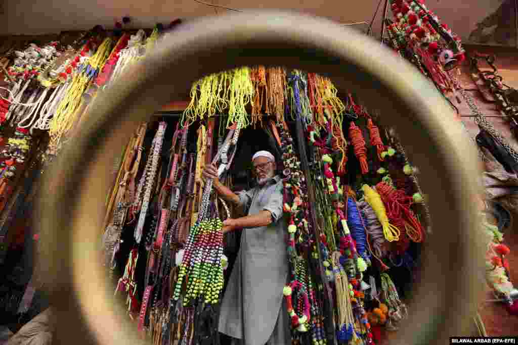 A man looks at ornaments for sacrificial animals that are on sale at a roadside shop ahead of the Muslim festival of Eid al-Adha in Peshawar, Pakistan.&nbsp;