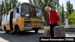  Една от евакуираните възрастни дами напуща родното си място с дребното багаж, който е съумяла да вземе 